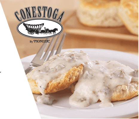 A close-up of a biscuit covered in country gravy alongside the Conestoga by Pioneer brand logo