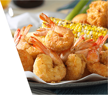 Plate of batter fried shrimp served with corn on the cob