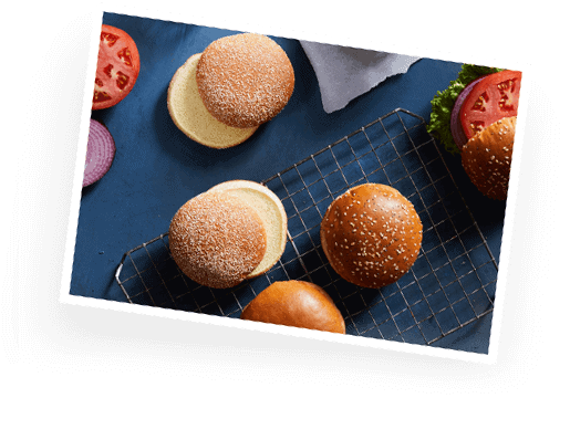 Overhead of various artisanal buns on a cooking rack.