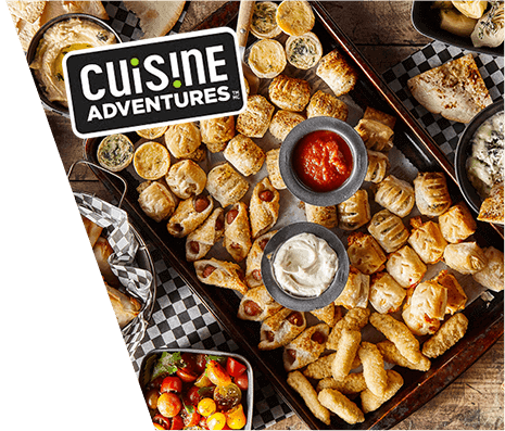 Overhead view of backing tray covered with various and Cuisine Adventure logo